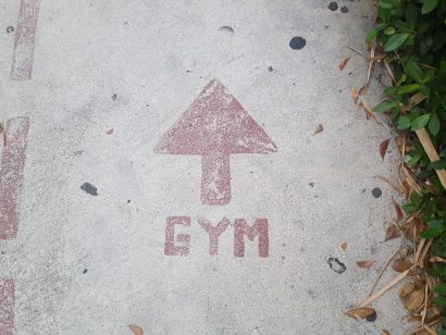 Alt text for an image of the word "gym" and an arrow painted on the ground, indicating the direction to the gym.